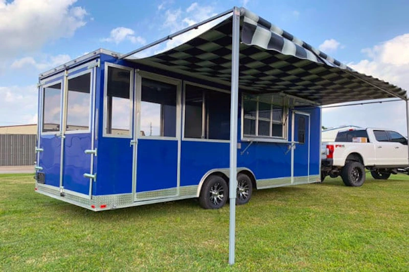 Blue Concession BBQ Porch Trailer with Awning parked on grass